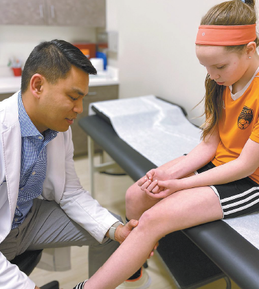 Dr. Edmund Ganal examines a patient.